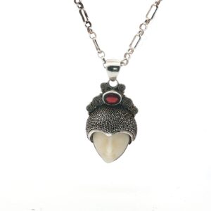 Embrace power, mystery, and timeless artistry with this extraordinary Natural Stone “Little Warrior” Pendant — a handmade masterpiece blending raw gemstone beauty with tribal-inspired design. The pendant features a carved gemstone face cradled in a richly textured sterling silver headdress, crowned with a vivid natural garnet gemstone. The result: a bold, wearable talisman that draws attention, sparks conversations, and captures character wherever you go.